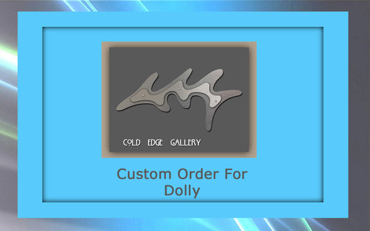 Image showing a framed metallic art piece resembling a stylized fish. Text reads "Cold Edge Gallery" on the artwork and "Custom Order For Dolly" below it.