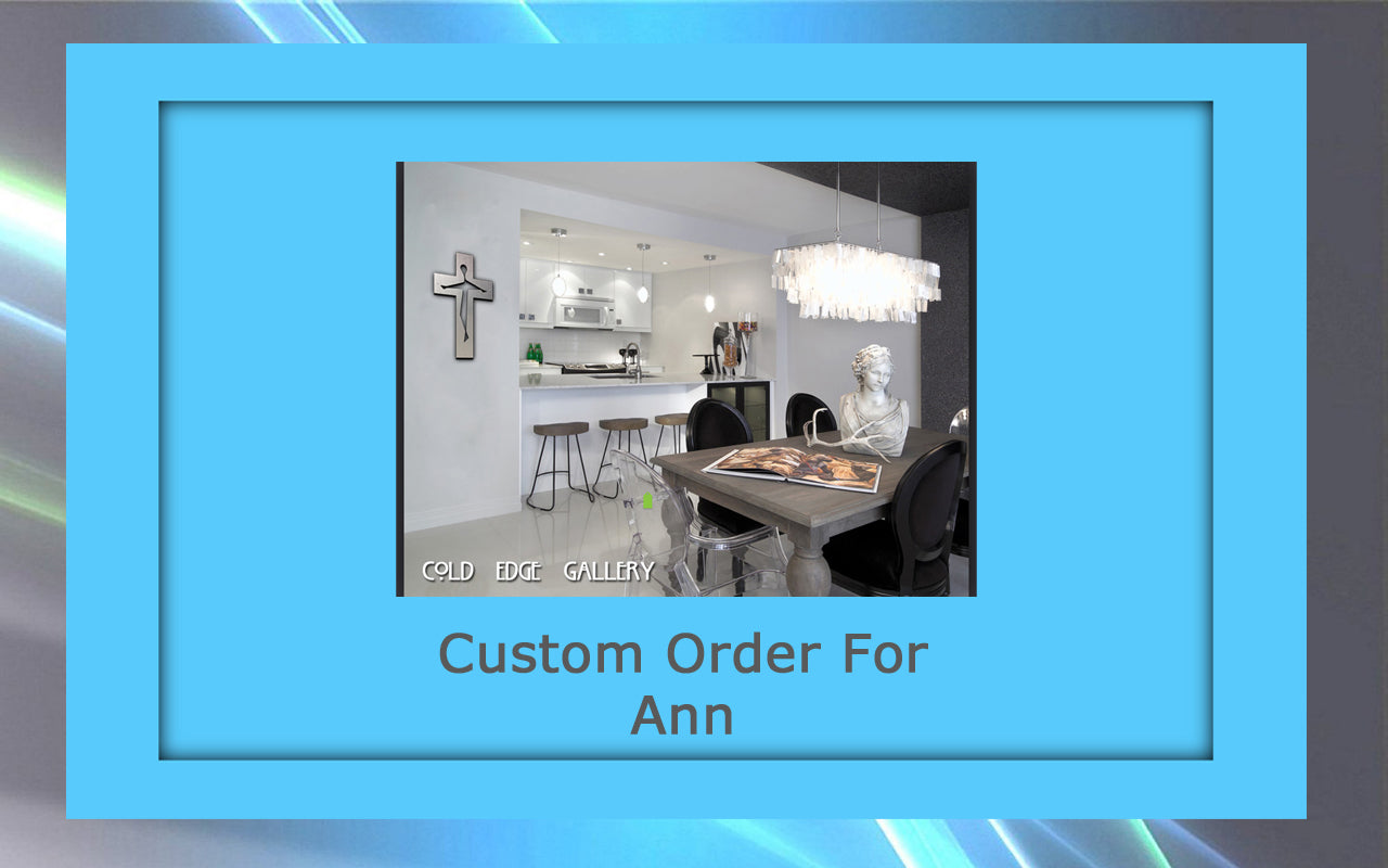 A modern kitchen and dining area featuring a silver cross on the wall, bar stools, a chandelier, a decorative bust, and a wooden dining table with custom artwork. Text: "Custom Order For Ann.