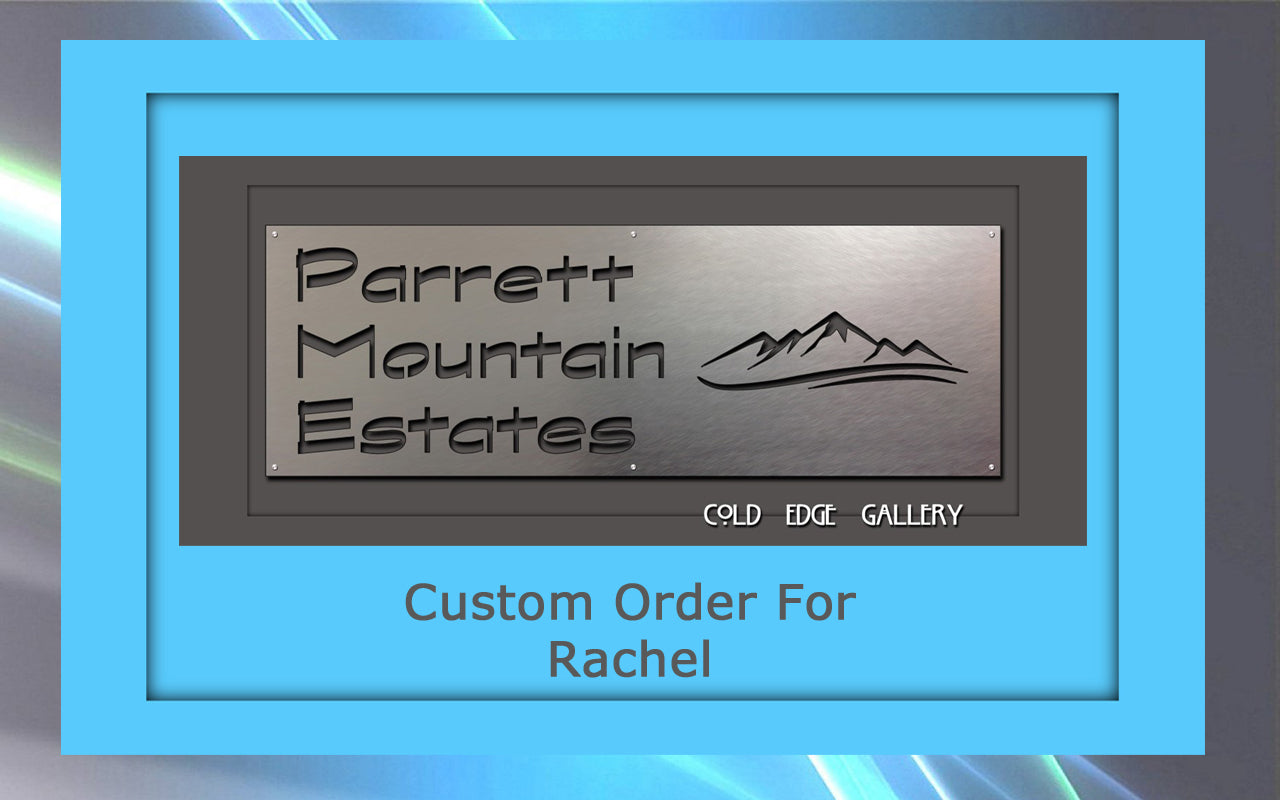 Metal sign with text "Parrett Mountain Estates" and a mountain logo, displayed in a blue frame. This custom artwork features the caption "Custom Order For Rachel" below.