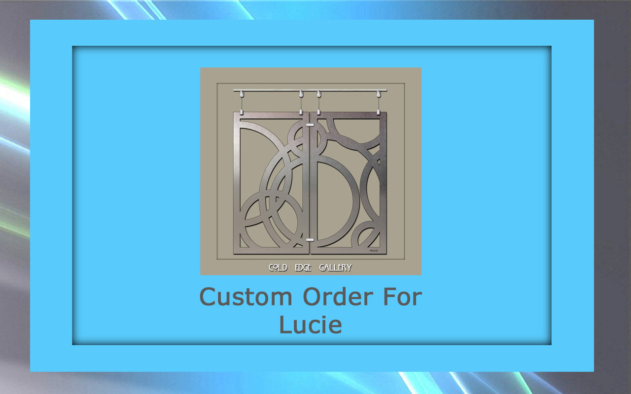 A framed image with text "Custom Order For Lucie" at the bottom and a decorative metal piece with abstract circular patterns in the center.