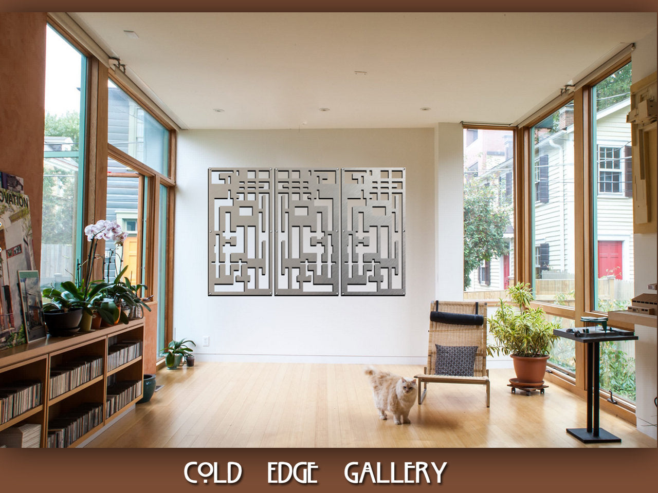 A spacious, well-lit gallery room with wall art resembling a maze, bookshelves, potted plants, and a cat walking on a wooden floor. The gallery is named "Cold Edge Gallery.