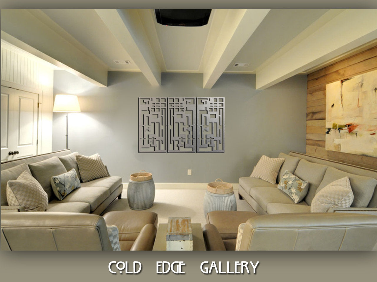 A modern living room with beige sofas, patterned cushions, abstract wall art, and a central coffee table. Ceiling beams and subdued lighting create a cozy atmosphere. Text at the bottom: "Cold Edge Gallery.