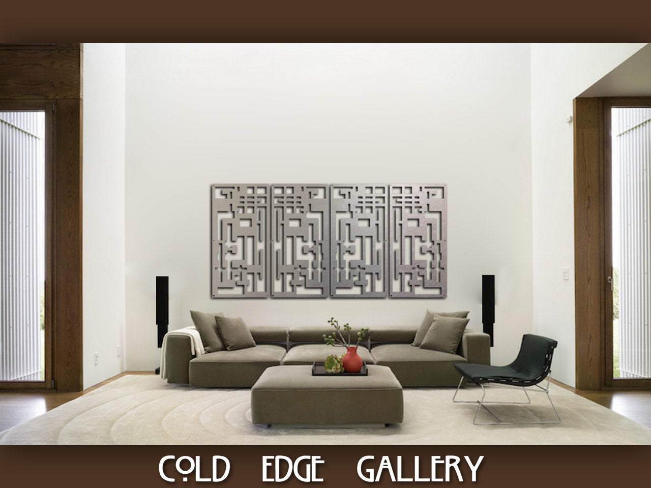 A modern living room features a large grey sectional sofa, a black lounge chair, and a central coffee table. Three abstract metal wall art pieces are displayed on a white wall above the sofa.