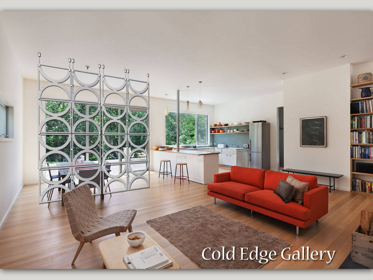 Modern open-plan living room featuring a red sofa, minimalist furniture, a kitchen island with bar stools, and a unique circular shelving divider. A window provides a view of greenery. Text reads: "Cold Edge Gallery".