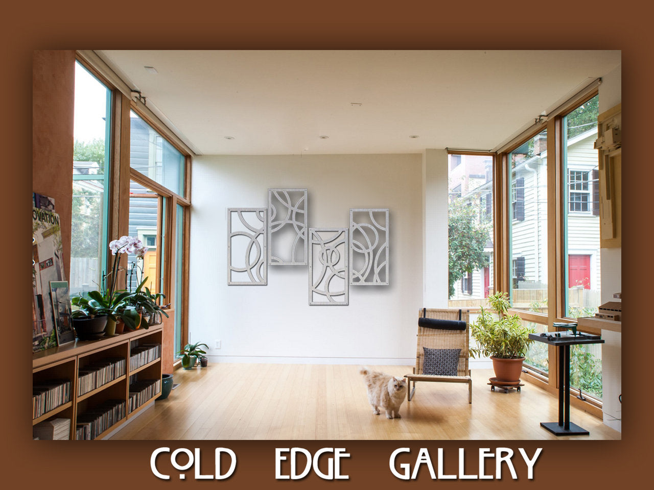 A modern gallery room with wooden floors and large windows features abstract wall art and a few pieces of furniture, including a chair. A cat is walking on the floor. The text reads "Cold Edge Gallery.