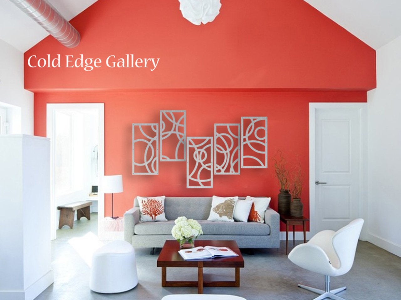 A modern living room with red walls, white ceiling, and contemporary furniture. Decorative white geometric panels hang on the wall with text "Cold Edge Gallery" in the upper left corner.